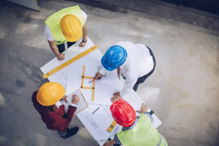 Engineers looking at blueprints on construction site