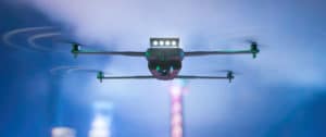 Flying drone. Night city in the background. Mixed media.
