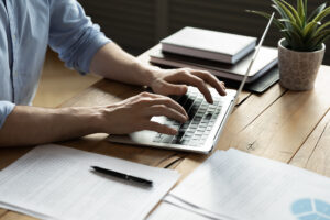 Close up businessman using laptop, sitting at work desk