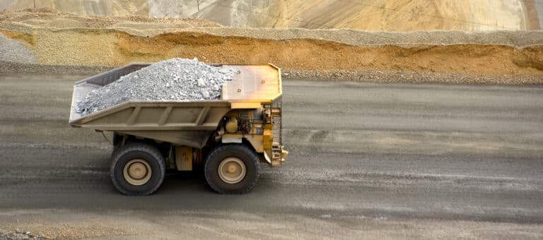 Yellow large dump truck in Utah copper mine seen from above