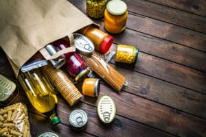 Non-perishable foods coming out a paper bag.