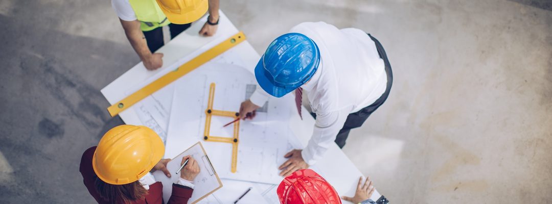 Engineers looking at blueprints on construction site