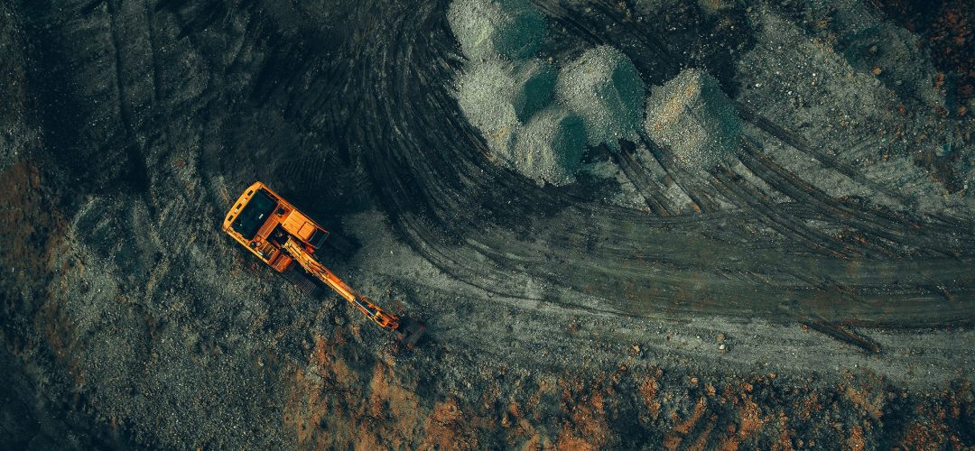 bright excavator at work on a dark background view from a drone