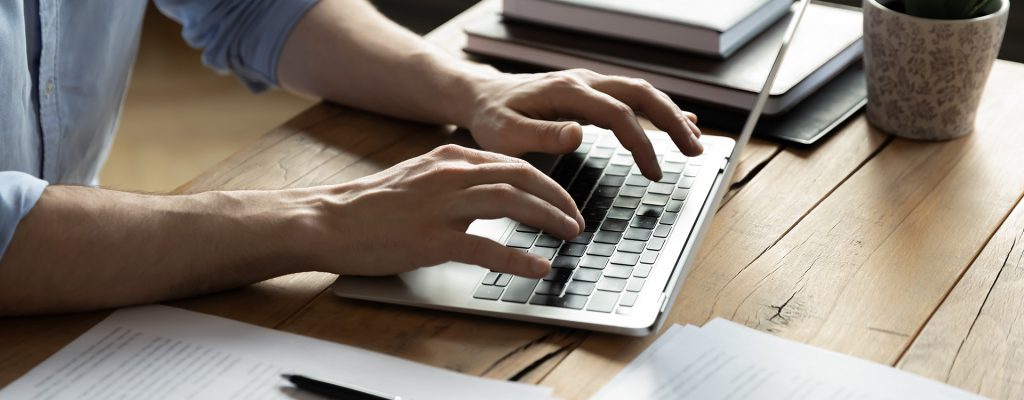 Close up businessman using laptop, sitting at work desk