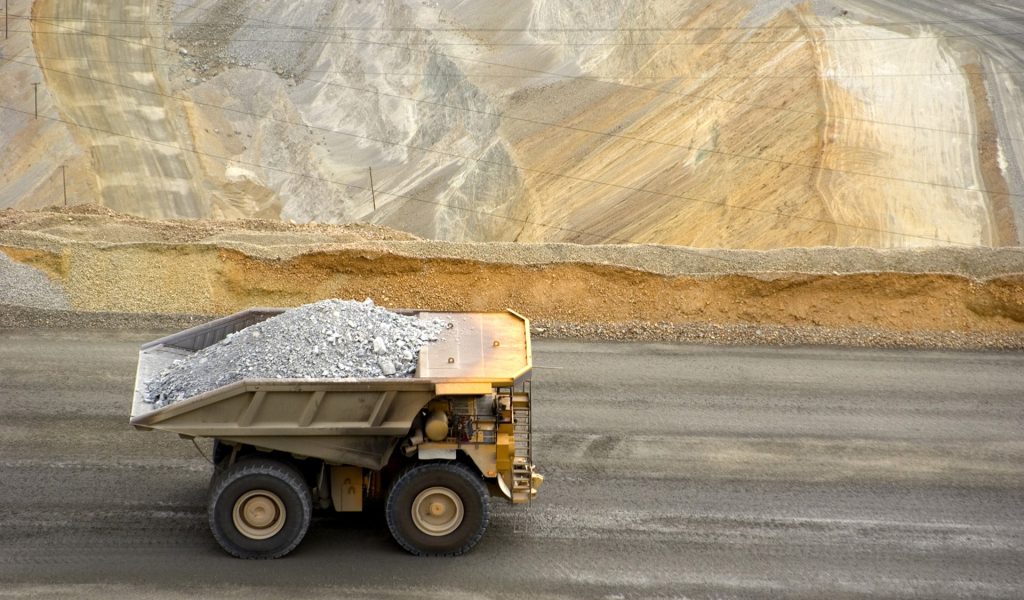 Yellow large dump truck in Utah copper mine seen from above